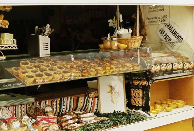 Colorful array of fresh Portuguese seafood including octopus, sardines, shrimp, and mussels on ice at a coastal market